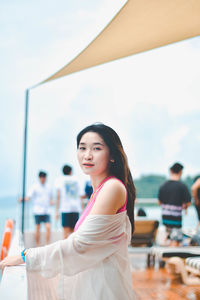 Portrait of young woman standing at beach