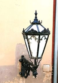 Close-up of street light against building wall