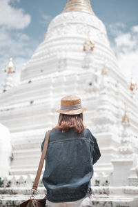 Rear view of woman looking at temple against building
