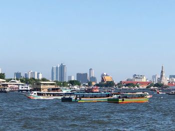 View of sea and buildings against clear sky