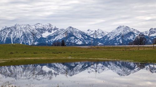 Scenic view of snowcapped mountains against cloudy sky