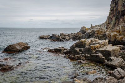 Rocks on beach against sky