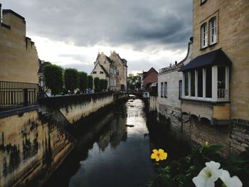 Canal amidst buildings against sky