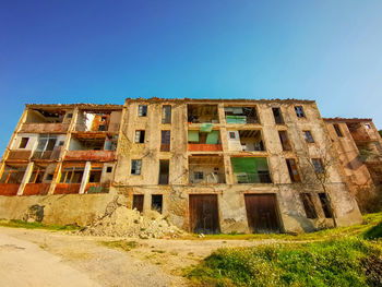 Low angle view of old building against clear blue sky