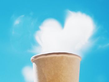 Heart shape cloud over disposable cup