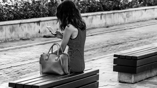 Side view of woman using mobile phone