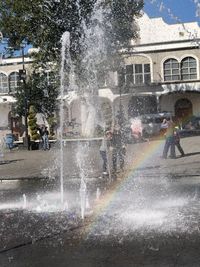 People on street against buildings in city