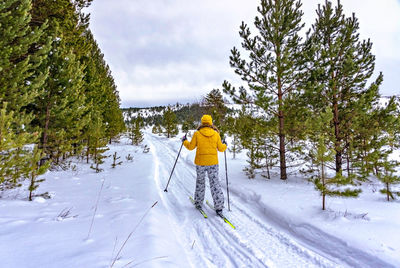Full length of woman skiing on snow covered field