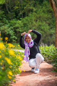 Full length of woman with pink flowers on land