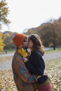 Side view of couple kissing woman