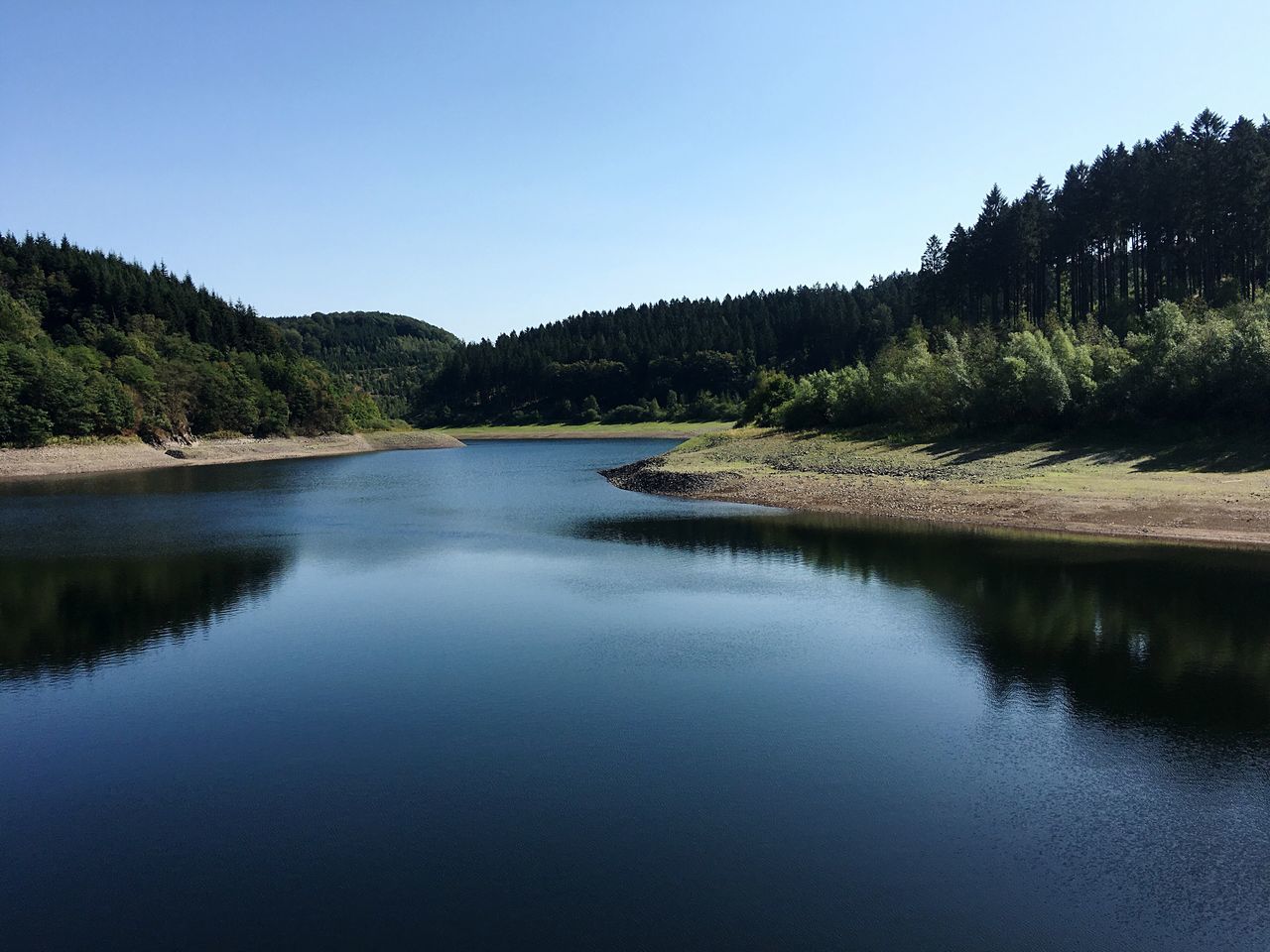 VIEW OF CALM LAKE AGAINST CLEAR SKY