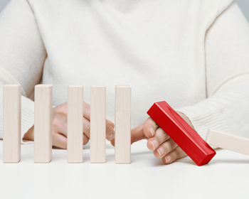 Midsection of woman with toy blocks on white background