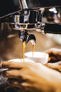 Cropped hands of person using coffee machine