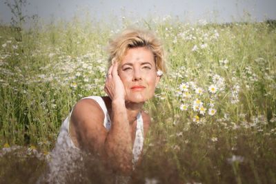 Portrait of woman sitting amidst flowers