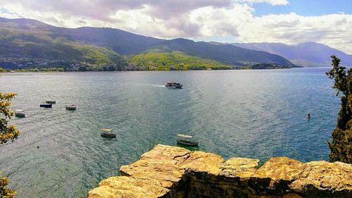 Scenic view of sea and mountains against sky