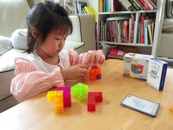 Cute girl with toy sitting on table