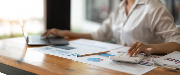 Midsection of businessman working on table