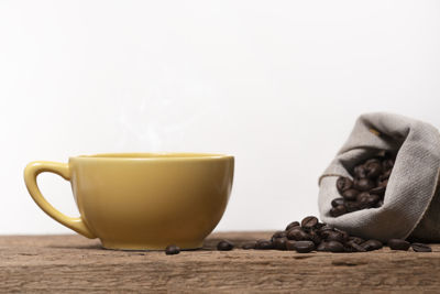 Close-up of coffee cup on table against white background