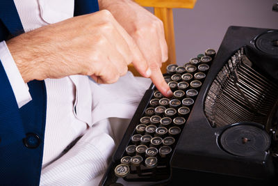 Close-up of man using typewriter.