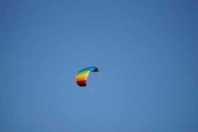 Low angle view of kite against clear blue sky