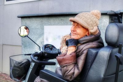 Senior woman sitting on wheelchair during winter