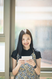 Portrait of smiling young woman using mobile phone