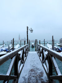 Pier over sea against sky during winter