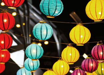 Low angle view of illuminated lanterns hanging at night