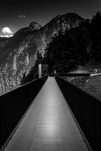 Footbridge amidst mountains against sky