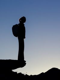 Low angle view of silhouette woman standing against clear sky