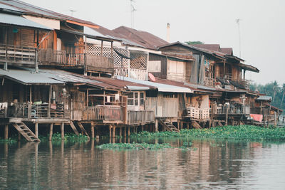 Buildings by river against sky