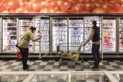 Couple choosing at refrigerated section in supermarket