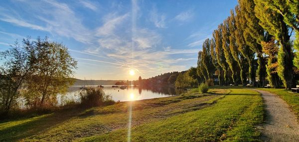 Scenic view of lake against sky with the sun