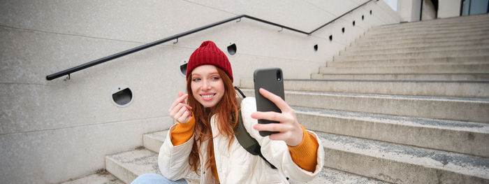 Portrait of young woman sitting on staircase