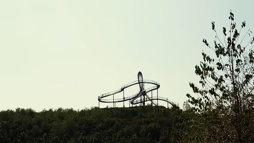 Low angle view of amusement park against clear sky