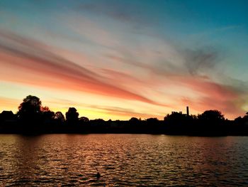 Scenic view of lake against orange sky