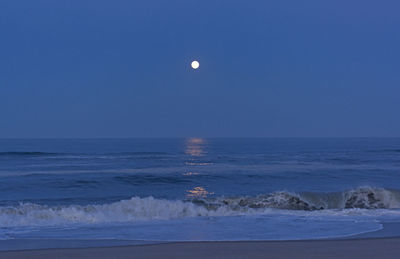 Scenic view of sea against clear sky at night