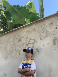 Portrait of boy standing against wall