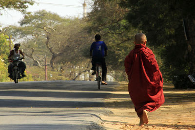 Rear view of monk walking on footpath