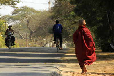 Rear view of monk walking on footpath