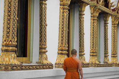 Rear view of senior woman against temple building