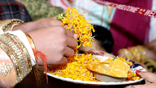Close-up of hand holding yellow rose flower
