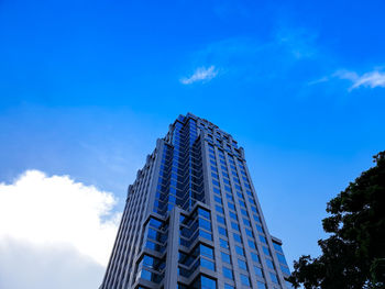 Low angle view of modern building against blue sky