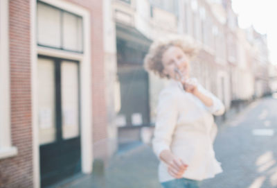 Midsection of woman standing by building in city