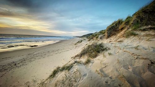 Scenic view of beach against sky during sunset