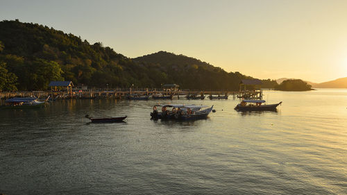 Boats moored on sea against clear sky