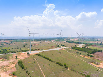 Windmills on field against sky