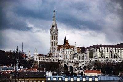 Buildings in city against cloudy sky