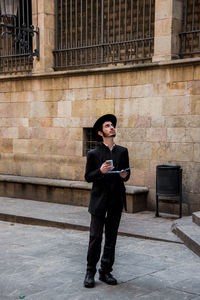 Full length of man using mobile phone in city