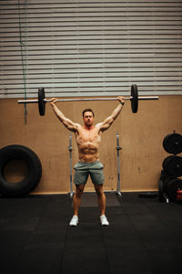 Shirtless man exercising in gym